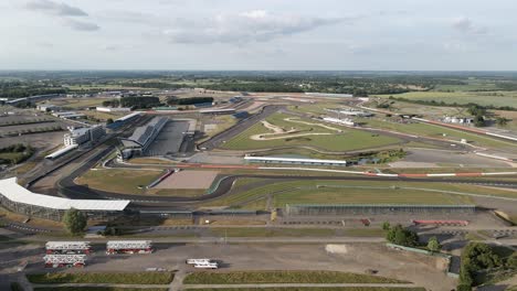 Aerial-dolly-view-across-Silverstone-British-motorsport-race-track-circuit-and-England-landscape