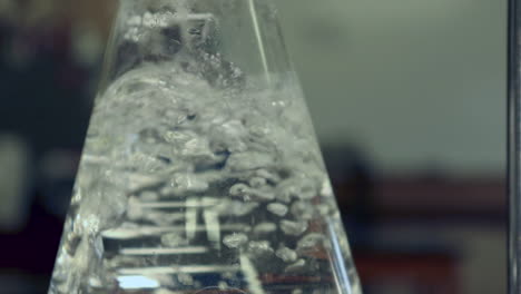 Close-up-of-surface-of-water-boiling-in-an-erlenmeyer-flask