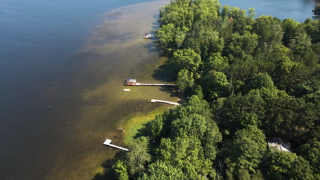 Vista-Panorámica-Del-Agua-Verde-De-La-Orilla-Del-Lago-Y-Muelles-Privados-Con-árboles-Verdes-Vibrantes