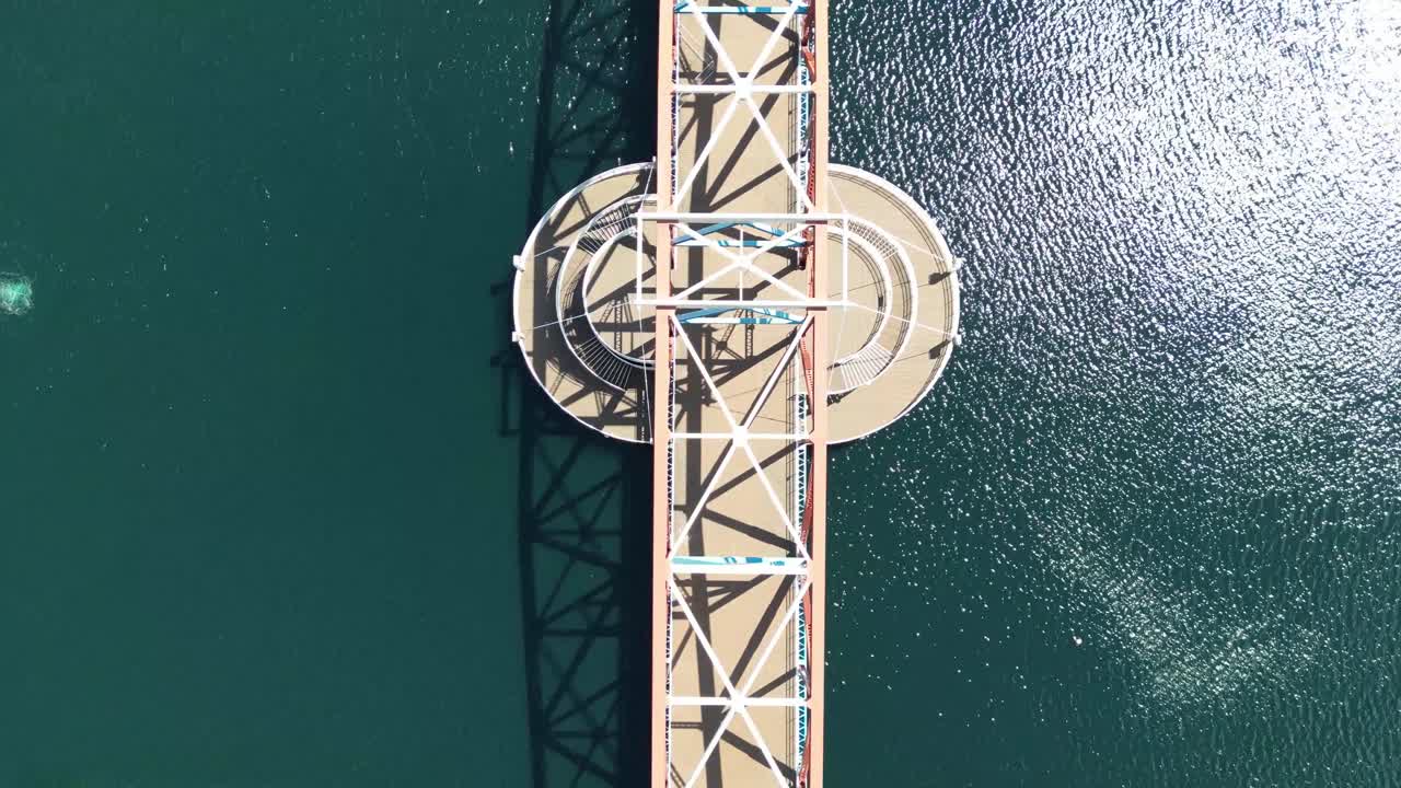 로리 센터 옆에 있는 샐퍼드 부두에 있는 인도교 위의 공중 드론 비행은 아래 에메랄드 그린 와트의 조감도를 보여줍니다.