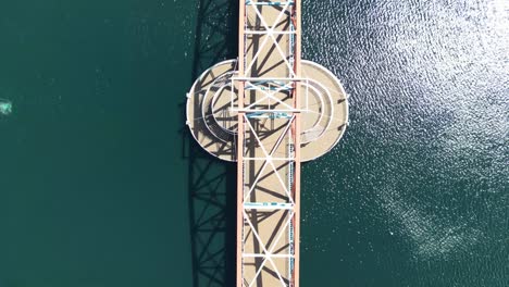vuelo aéreo de drones sobre el puente peatonal en los muelles de salford junto al centro lowry que muestra una vista de pájaro de los watrs verde esmeralda debajo