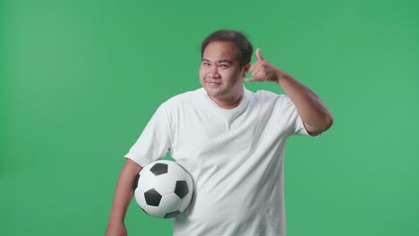 サッカーボールを握り電話のジェスチャーをしている男性