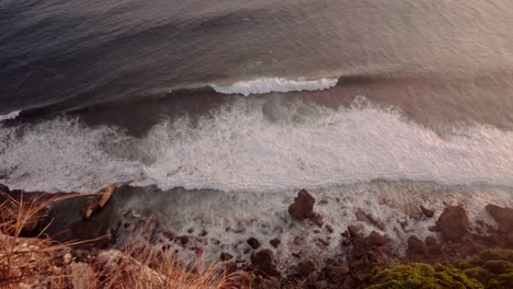 warm sunset or sunrise with ocean, waves and rocks