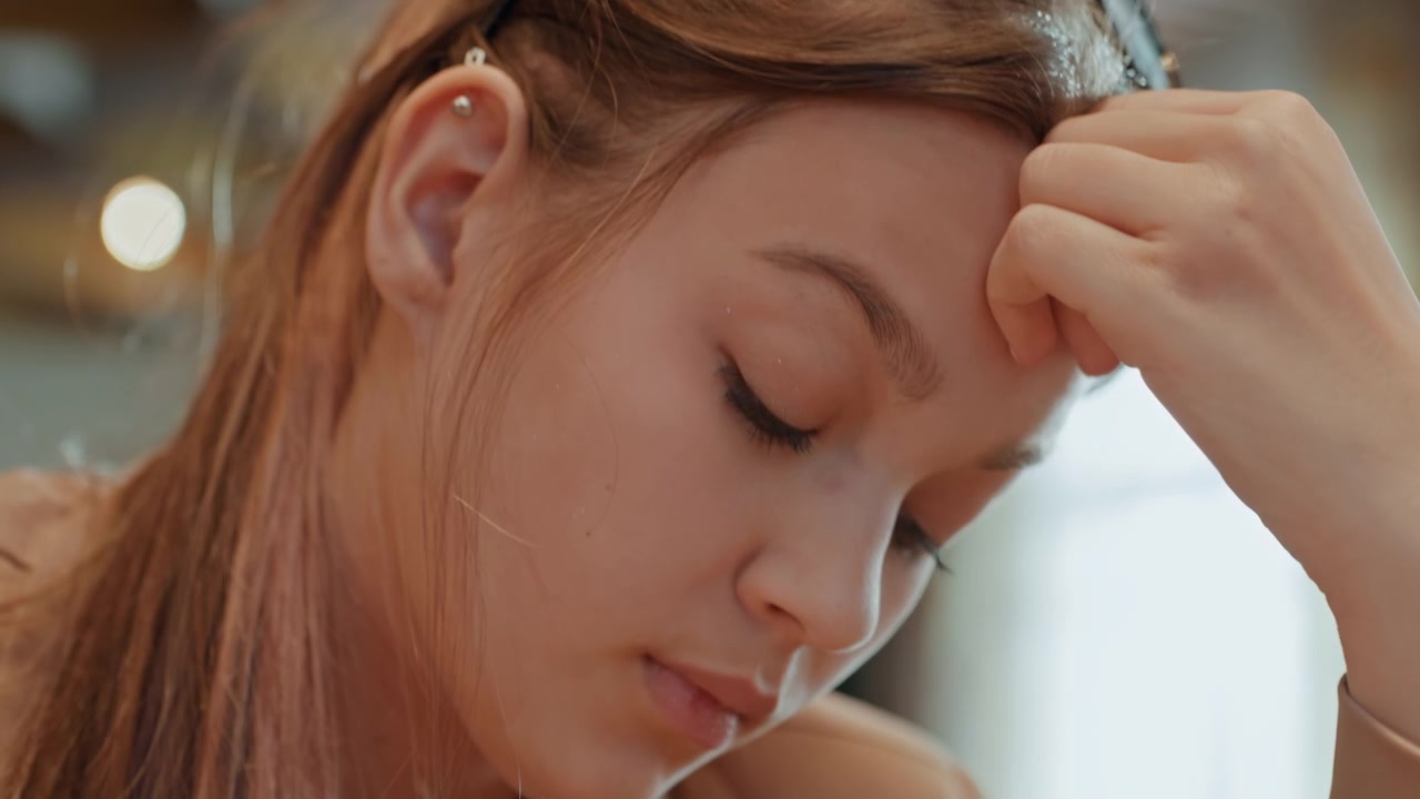 Una donna mostra stanchezza durante la pausa. Un primo piano cattura la donna che prova ansia e spossatezza durante il tempo libero. Immagine dettagliata di una donna che mostra preoccupazione e affaticamento in una tranquilla pausa dal lavoro.