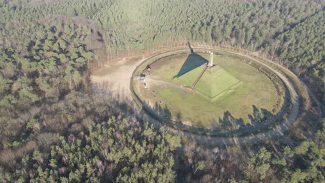 wide aerial of austerlitz pyramid surrounded by forest. the piramide van austerlitz is a monument in the netherlands, built in 1804 as a tribute to napoleon bonaparte.