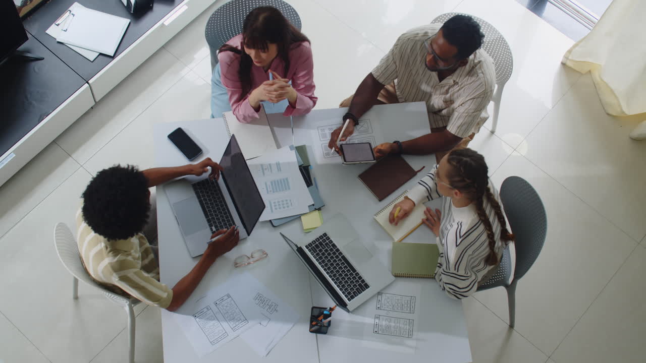 Multiethnic UX Designers Discussing Ideas at Office Table