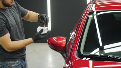 car service worker applying nano coating on a car detail.