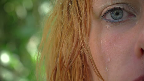 primer plano de la cara de una mujer hermosa con maquillaje natural y cabello mojado de pie en la jungla entre plantas exóticas