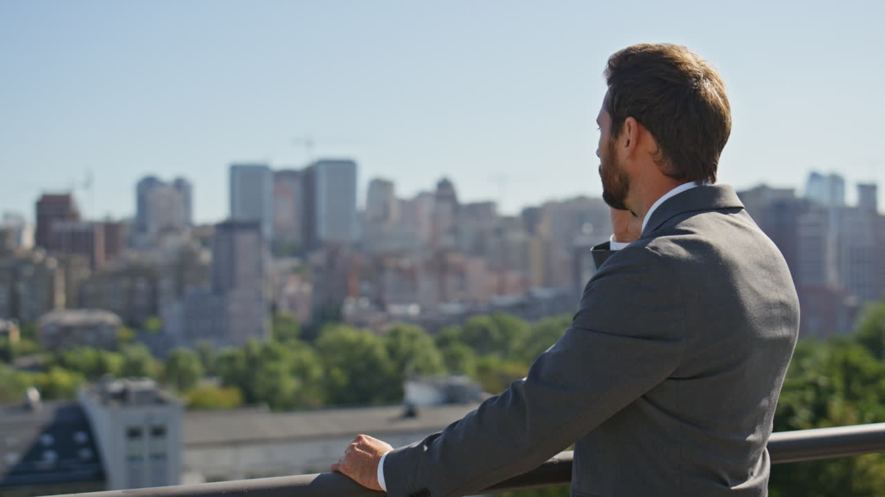 gerente exitoso llamando a la calle mirando el panorama de la ciudad soleada de cerca.
