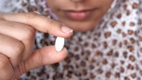 woman holding a pill