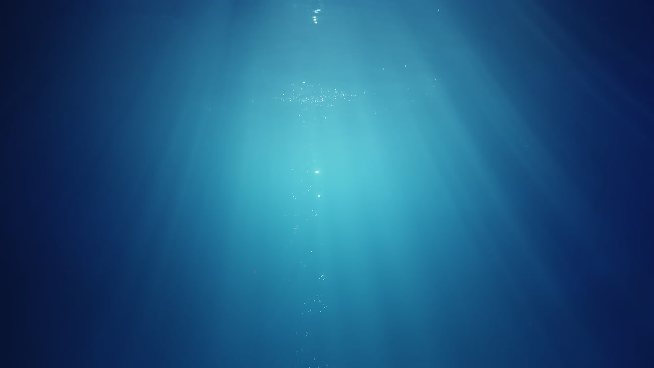 위에서 빛나는 수중 햇빛 광선이 깊고 맑은 푸른 물을 통해 아름다운 물 조명 반사 커튼을 만듭니다.