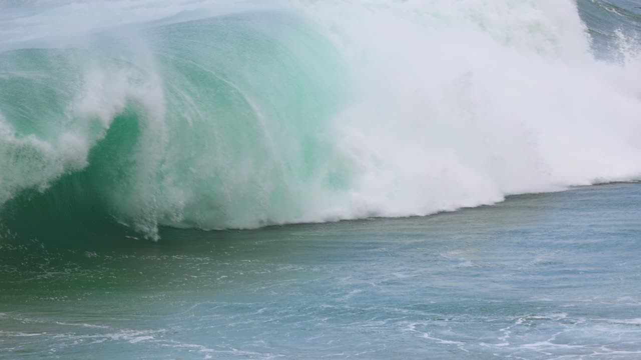 Dynamic ocean waves crash against the shore at Port Campbell, Australia. Captured in bright daylight, showcasing the sea's raw power