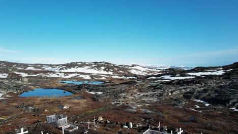 Massive-burial-site-with-white-crosses-near-Ilulissat,-aerial-view