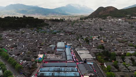 overhead drone of central square in lijiang old town with streets and rooftops, aerial pullback