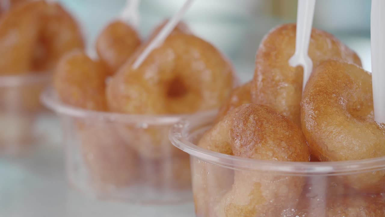 Golden fried sweet pastries in individual serving cups