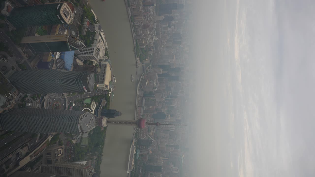 Aerial view of Shanghai city skyline with the Oriental Pearl TV Tower and Huangpu River under a hazy sky