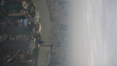 aerial view of shanghai city skyline with the oriental pearl tv tower and huangpu river under a hazy sky