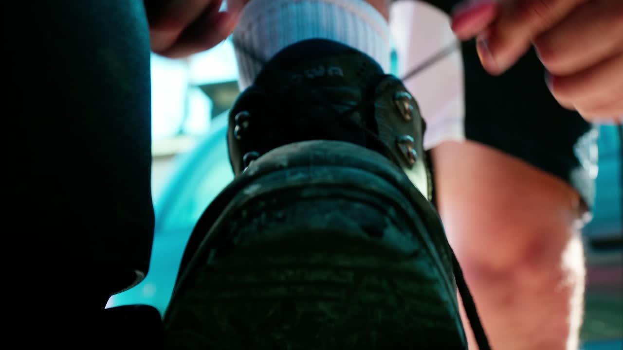 남자는 등산화를 끈다