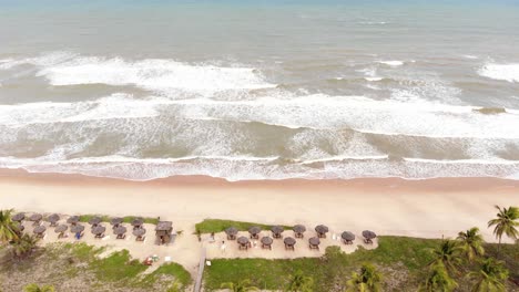 Drone-bungalows,-coconut-trees-and-waves