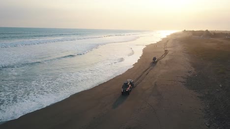 Drohne-Luftaufnahme-Von-3-Autos,-Die-über-Den-Sand-Fahren,-Wellen-Brechen,-Ufer-In-San-Jose,-Guatemala