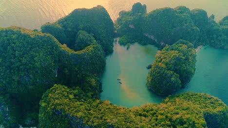 aerial. top view of green island and beach with traditional thai boat at the sunset.