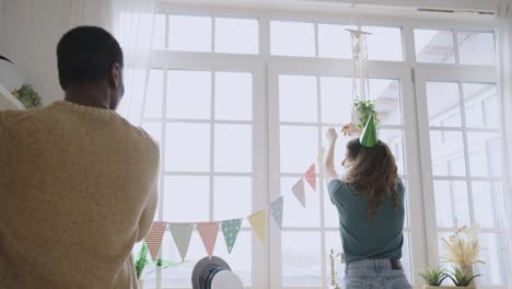 international couple hangs pennant banners on flowerpots