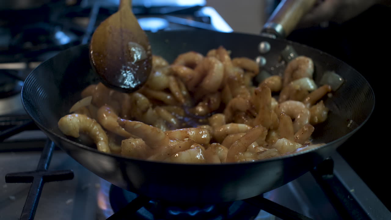 Gamberi piccanti congelati cucinati, riscaldati e mescolati nel wok in cucina
