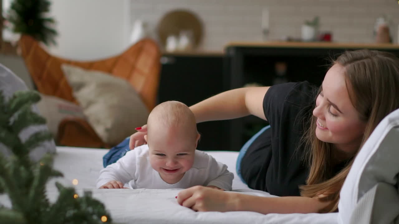 인생에서 가장 좋은 순간, 사랑하는 행복한 젊은 어머니가 모유를 먹이는 아들을  ⁇ 안고, 눈  ⁇ 색 담요 위에,  ⁇ 색 배경 위에. 사랑, 가족, 행복 개념: 아이들, 아이들, 아기, 아기들