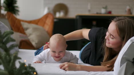 the best moments from life, a loving happy young mother hugs a nursing son, on a snow-white blanket, on a white background. concept of love, family, and happiness concept: children, kids, baby, babies