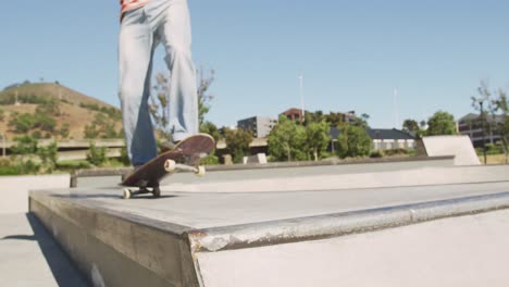 caucasian man riding and jumping on skateboard on sunny day