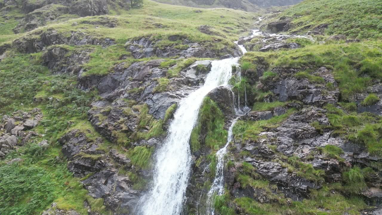 la furiosa cascada que cae en cascada por la montaña es en cámara lenta después de días de fuertes lluvias, el dron aéreo se mueve lentamente, parte 7, buttermere, lake district, reino unido