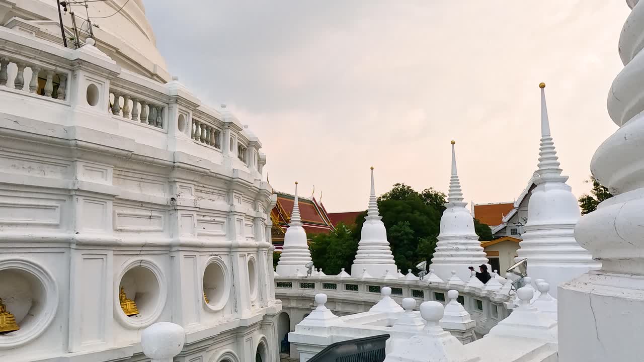 Aerial footage of Wat Prayurawongsawas Worawihan in Bangkok, showcasing its stunning white architecture under soft, natural lighting