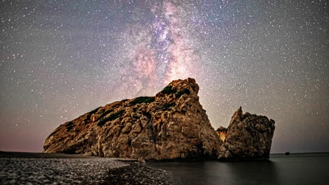 timelapse of the milky way moving in the sky behind a rock formation