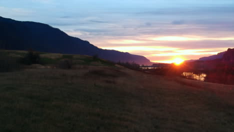 drone footage going fast along the ground then rising into the air revealing the beautiful coumbia river gorge sunset