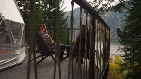 couple relaxing on a mountain lake cabin deck