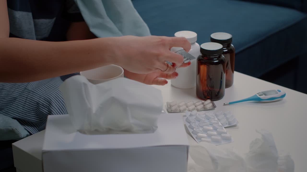 Close up of woman hand looking at bottle and tablets with pills