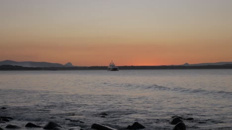 Schiff-Treibt-Auf-Dem-Wasser-In-Noosa-Am-Nördlichen-Ende-Der-Sunshine-Coast-Bei-Einem-Sonnenuntergang---Queensland,-Australien---Totale