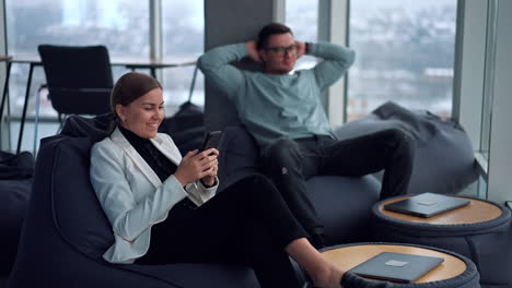 business people relaxing and using smartphones in a modern co-working space