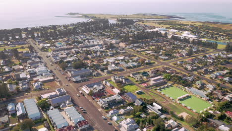 aerial top down of small town with driving cars on main road during beautiful summer day in australia