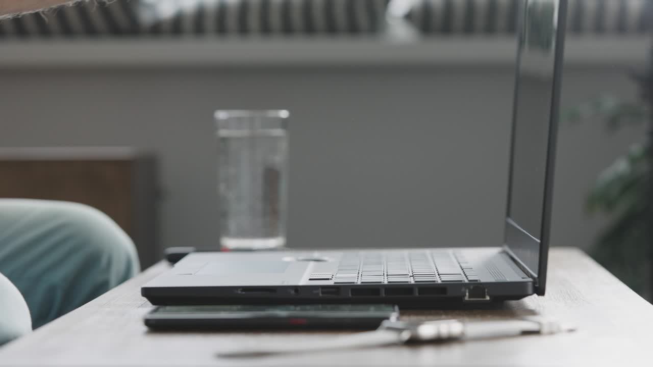 A man starts his working day from home. Male hands open a modern laptop