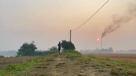 Toma-En-ángulo-Bajo-Del-Hombre-Trotando-Hacia-La-Cámara-En-Una-Mañana-Nebulosa-Causada-Por-La-Planta-De-Gas