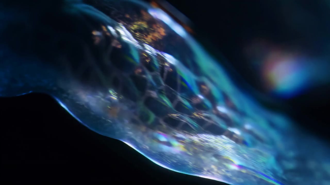 Abstract time-lapse of translucent blue gel undergoing dynamic transformation from concentrated sheet to fragmented film