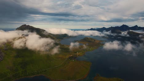 green nature coastline of northern lofoten, norway. aerial during golden hour, flying through clouds