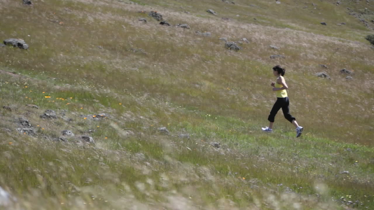 젊은 여자가 언덕을 뛰어 올라간다