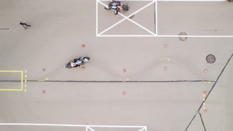 aerial shot of biker driving slalom through cones on the motorcycle