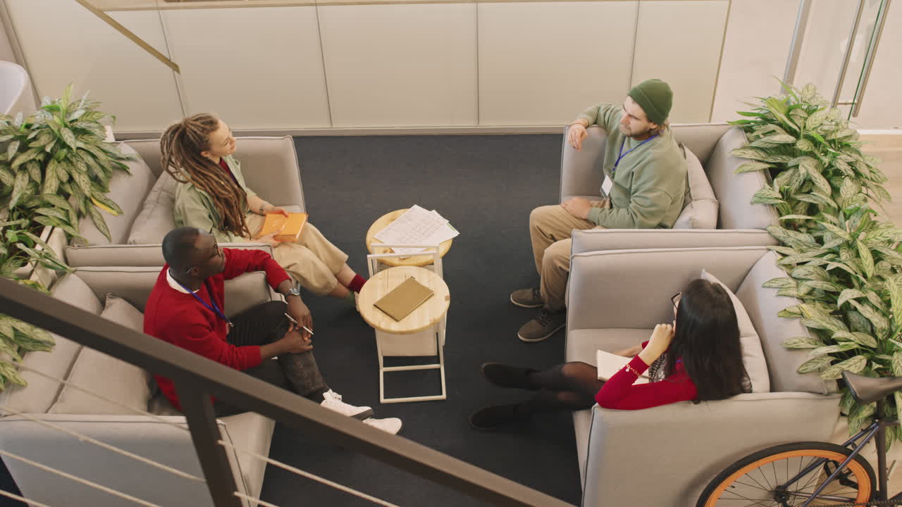 Young Businesspeople in Armchairs Chatting