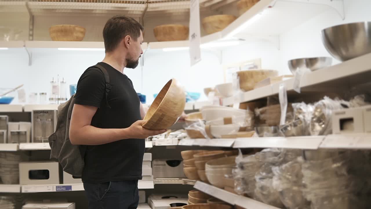 hombre comprando cuencos en una tienda de utensilios de cocina