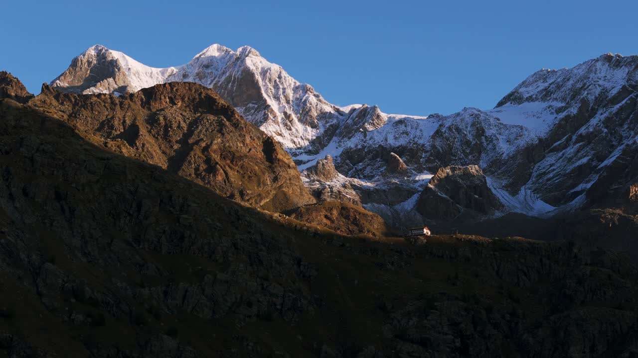 refugio alpino con las montañas de cima fontana en el fondo, italia ascendiendo desde el aire