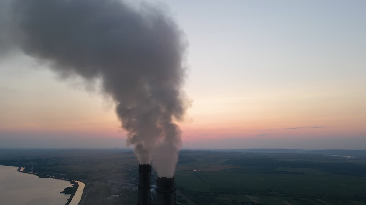 석탄 발전소의 공중 전망: 흑색 연기가 위로 이동하여 해가 지는 동안 대기를 오염시키는 화석 연료 개념으로 전기 에너지를 생산합니다.