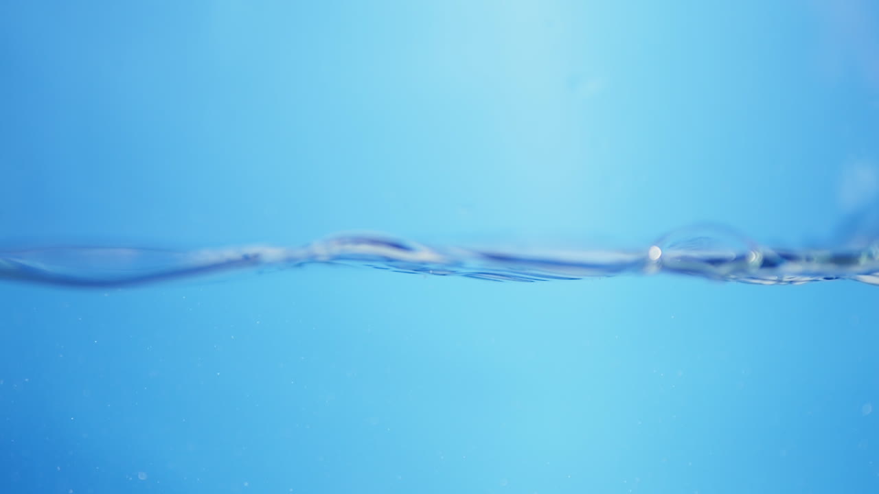 파란색 배경으로 표면에 있는 물의 파도_ 느린 움직임